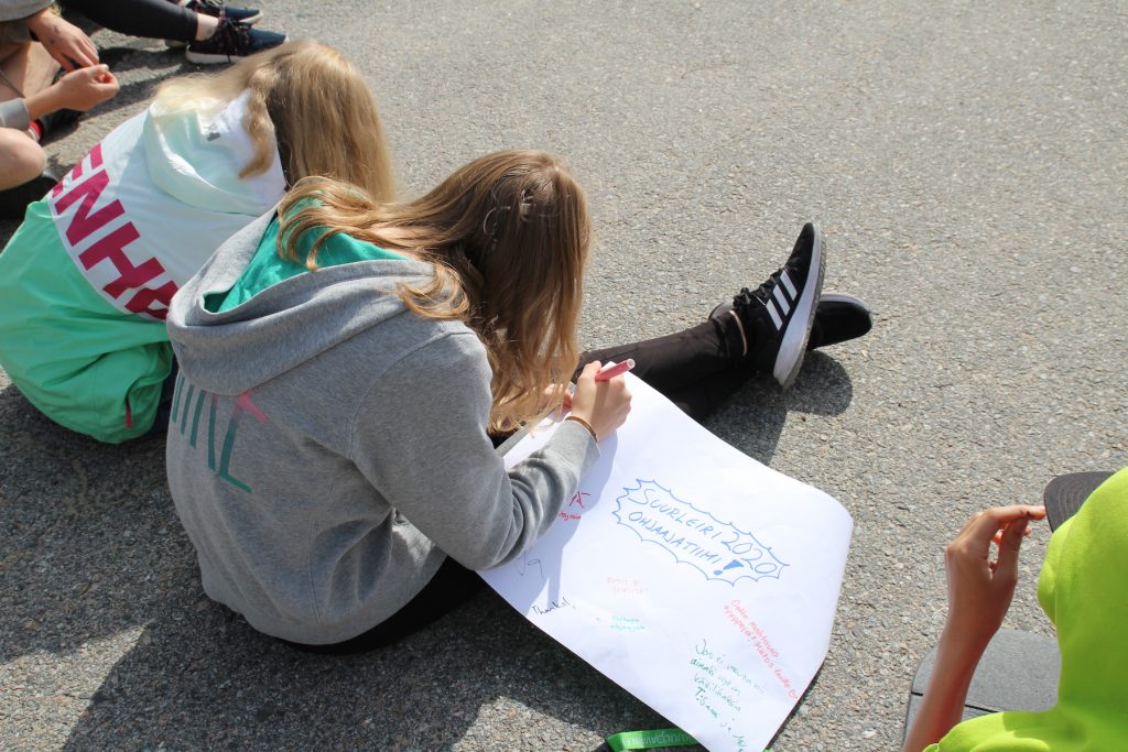 Kuvassa nuoret kirjoittamassa viestejään ja palautetta ohjaajille / kuvia ja kertomuksia Suurleiriltä