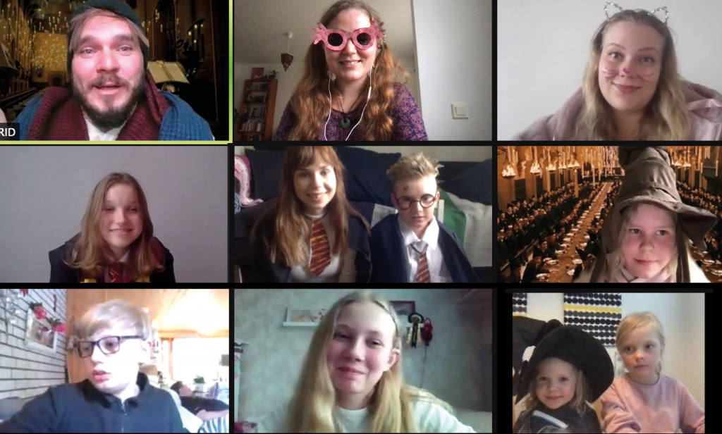 Kuvassa Zoom-näyttö, jossa monta lasta ja aikuista hymyilee kameralle, osalla päällään Harry Potter -asuja