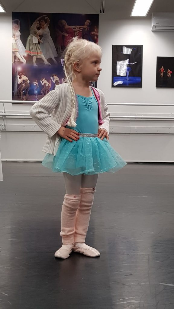 Pieni Eevi poseeraa kameralle ballerina-asu päällään ja kädet lantiolla