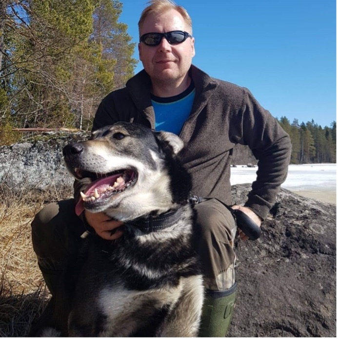 Kuvassa Antti poseeraa koiran kanssa kallion edessä
