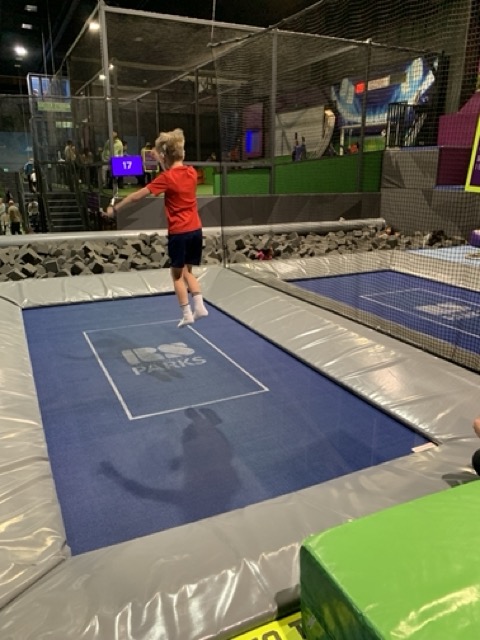 Kuvassa SI:ta käyttävä poika pomppimassa jättimäisellä trampoliinilla