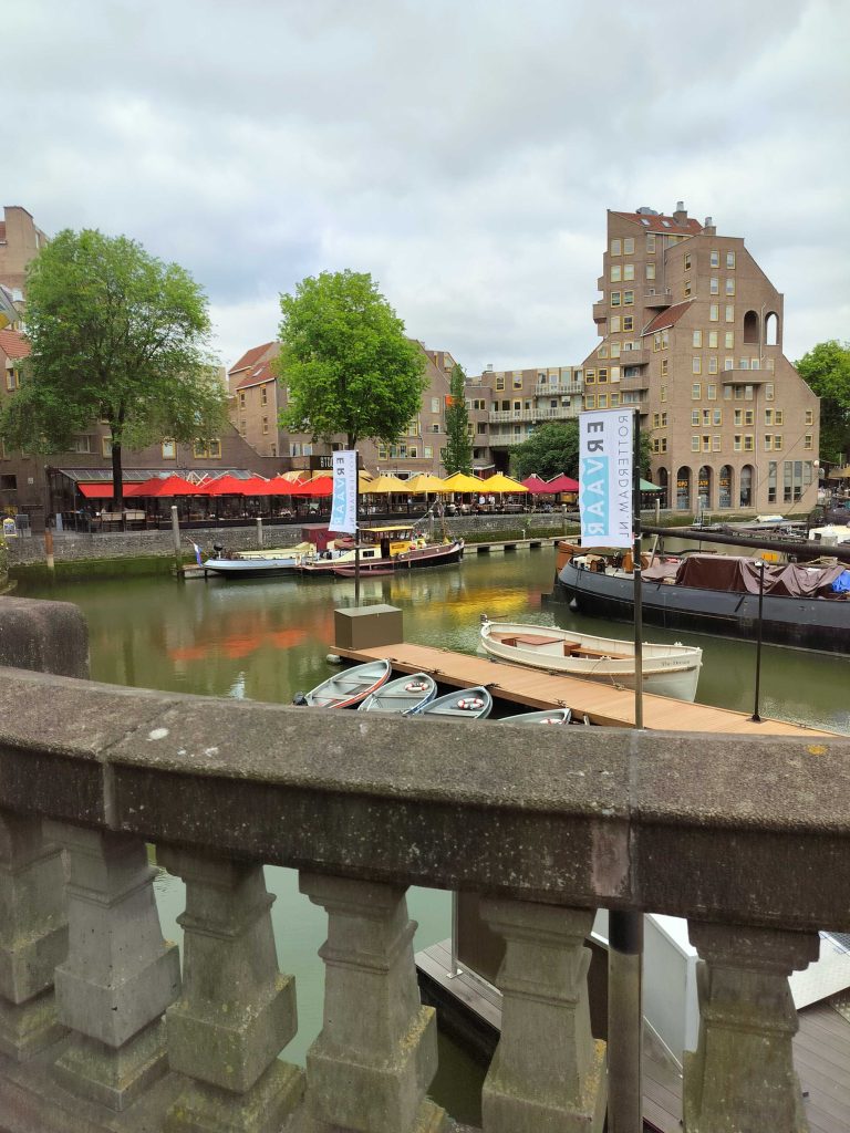 Kuvassa Rotterdamin vanha satama, etuallalla kaide ja taustalla vedessä näkyy veneitä.