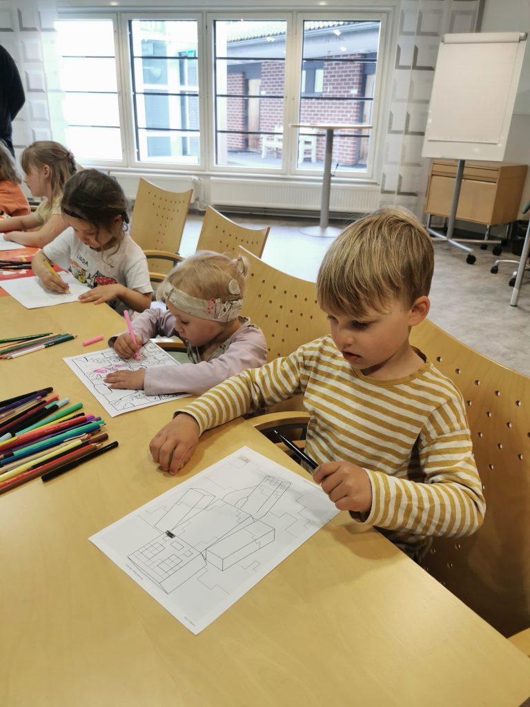 Pieniä lapsia pöydän ääressä piirtämässä.