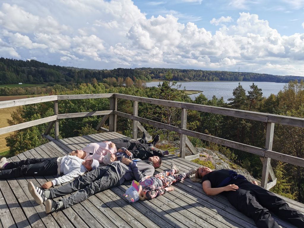 Vanhempia ja lapsia makoilemassa Siuntion näköalatornin huipulla.
