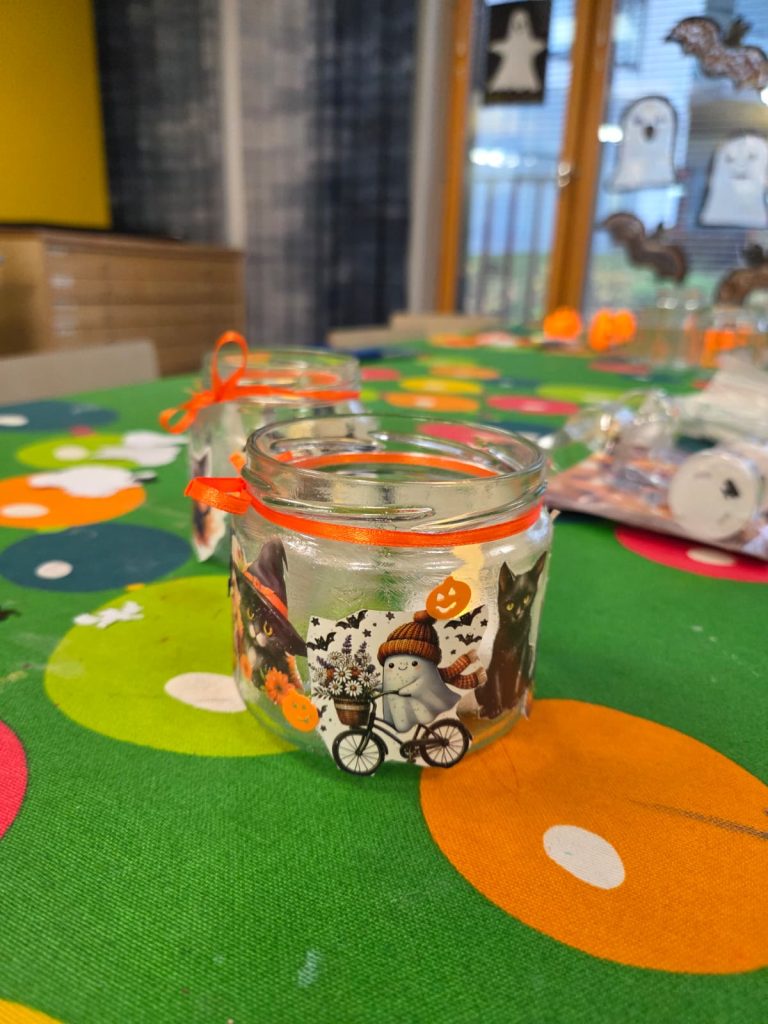 Leikkitreffeillä askarreltuja lyhtyjä aseteltuina pöydälle. Lyhdyissä on kummitus- ja kissatarroja.