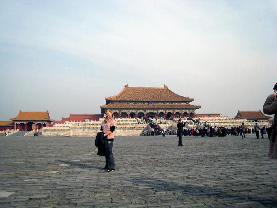 Suvi poseeraa Tiananmenin aukiolla, Kiinassa. Takana näkyy isoja palatseja.