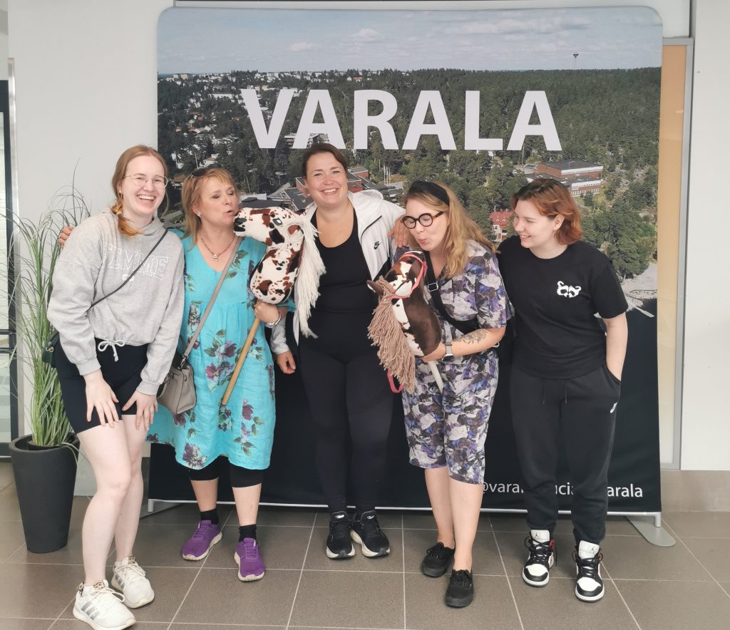 LapCI ry:n työntekijöitä poseeraa iloisina yhteiskuvassa Varalan julisteen edessä.