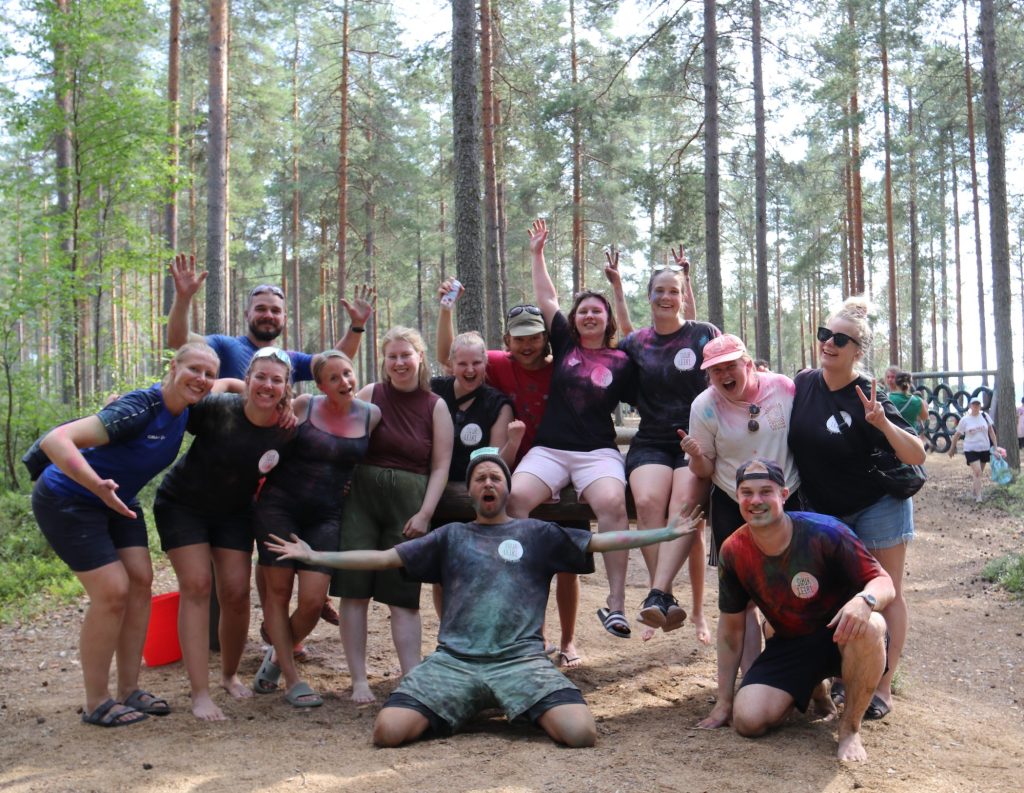Suurleirin ohjaajat iloisina ryhmäkuvassa metsän keskellä.